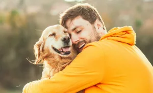 câine care plange cu lacrimi de fericire imbratisare cu stapanul / animale de companie